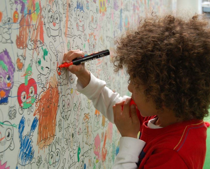 Child colouring on wall