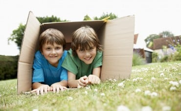 Children playing with a cardboard packing box